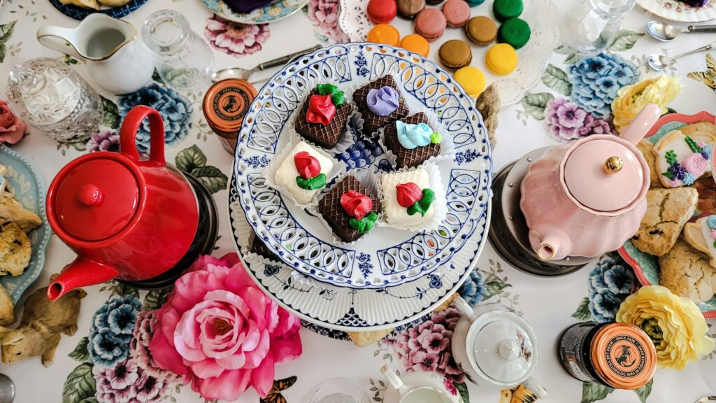 Dining room table set for tea party with delicious unhealthy food.